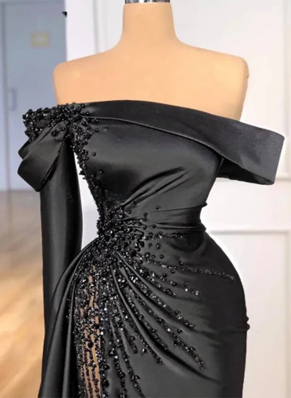 Close-up of the sequined satin fabric and off-shoulder detail of a wedding gown.