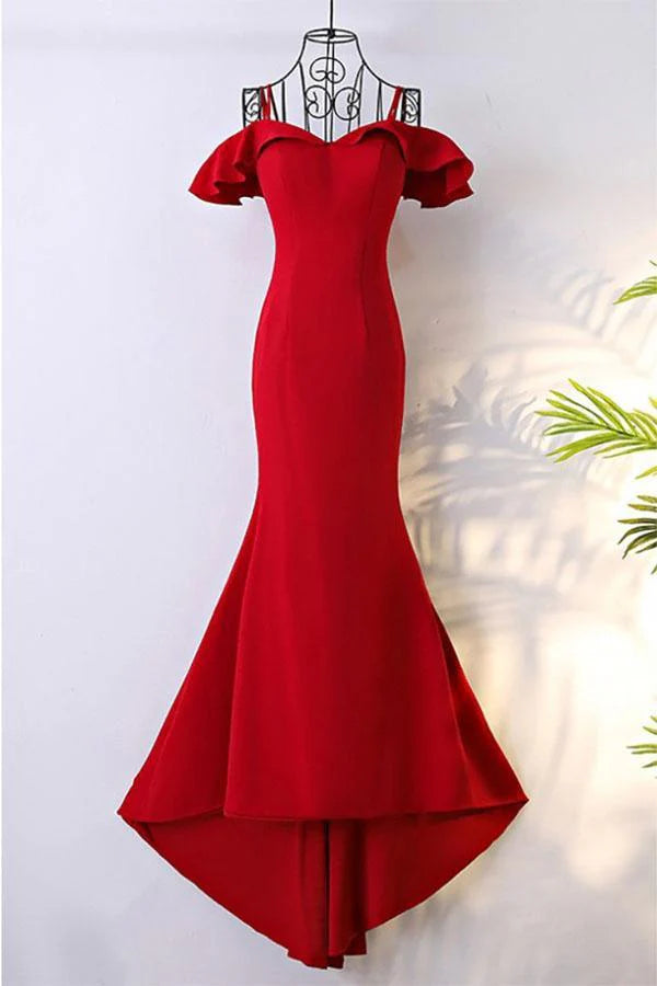 Woman wearing an elegant off-shoulder mermaid prom gown with a flowing train.