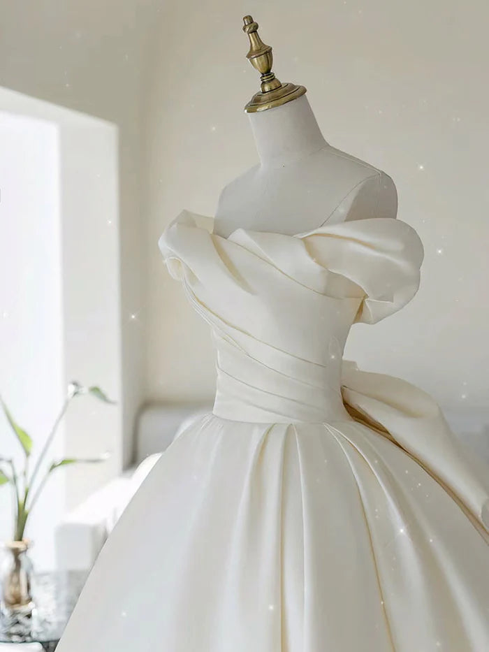Back view of an ivory off-shoulder satin long wedding dress, showcasing its elegant drape.
