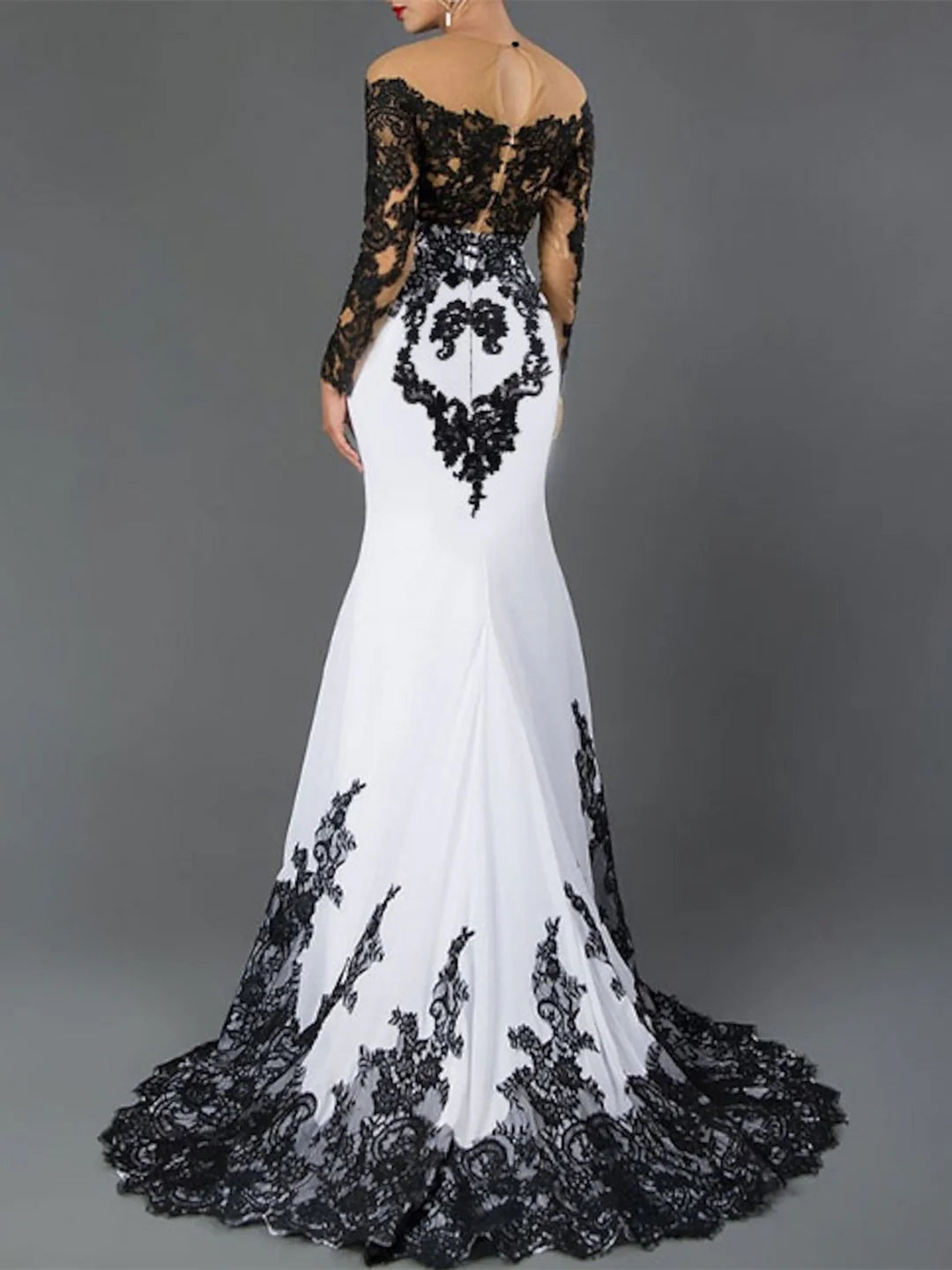 Woman wearing an elegant off-shoulder sheath prom dress with intricate applique details.