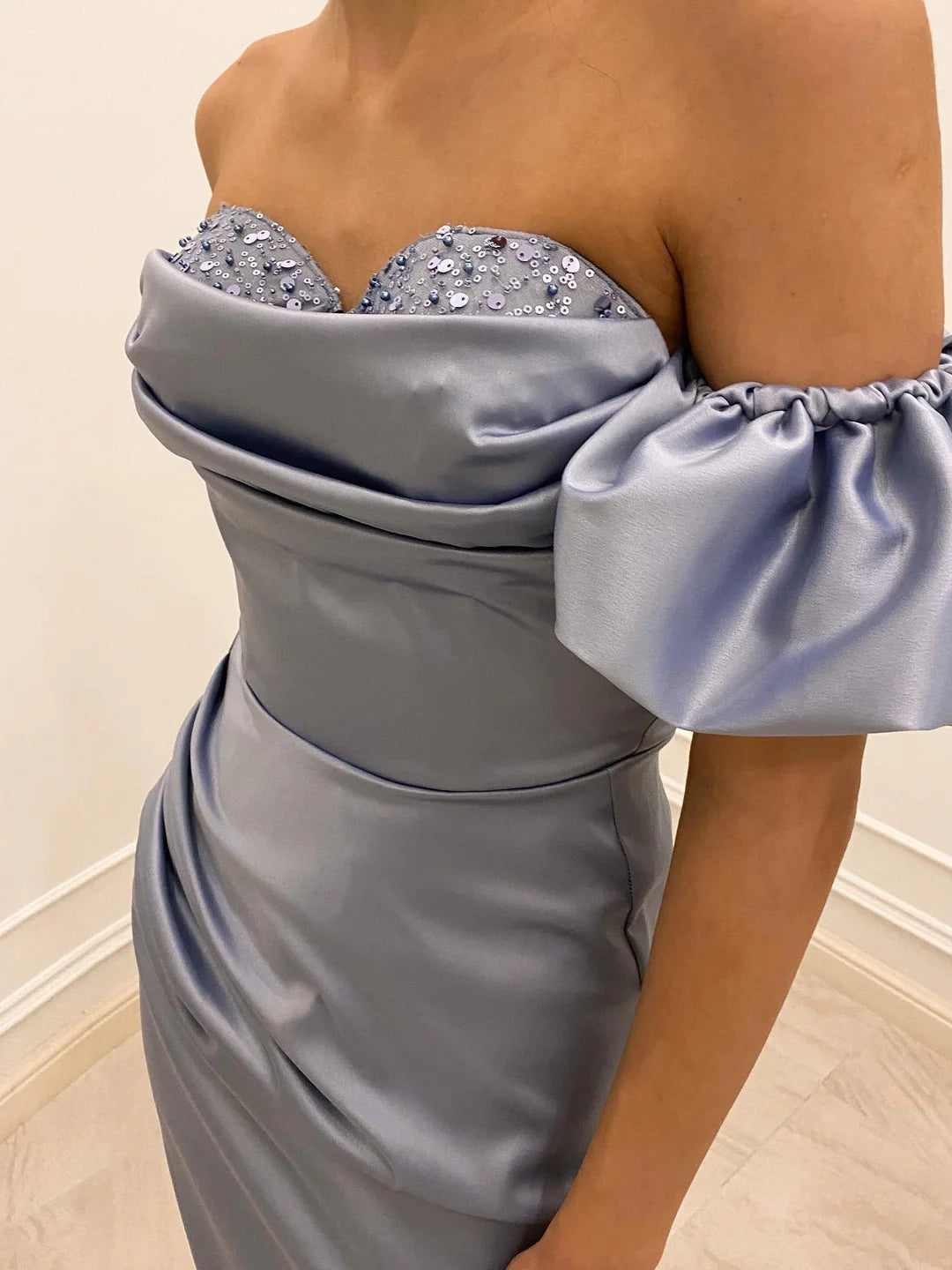 Full view of the sophisticated off-shoulder sheath dress, ideal for proms.
