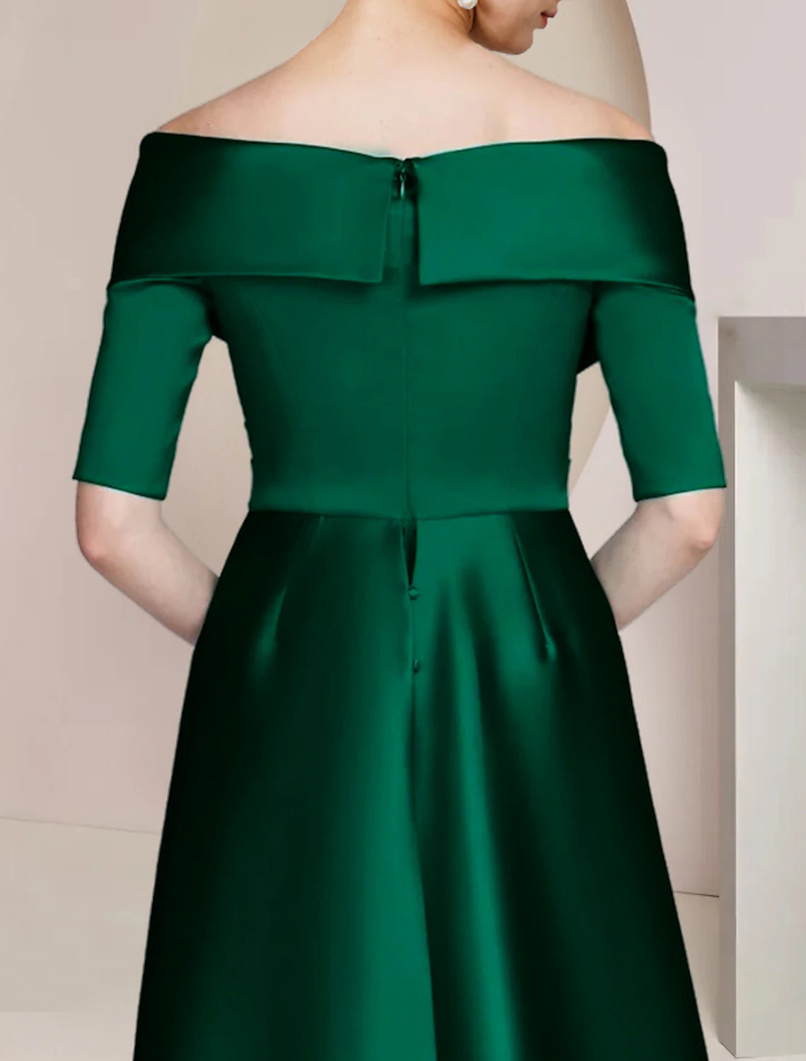 Close-up of the off-shoulder neckline and half sleeve on a navy blue satin dress.