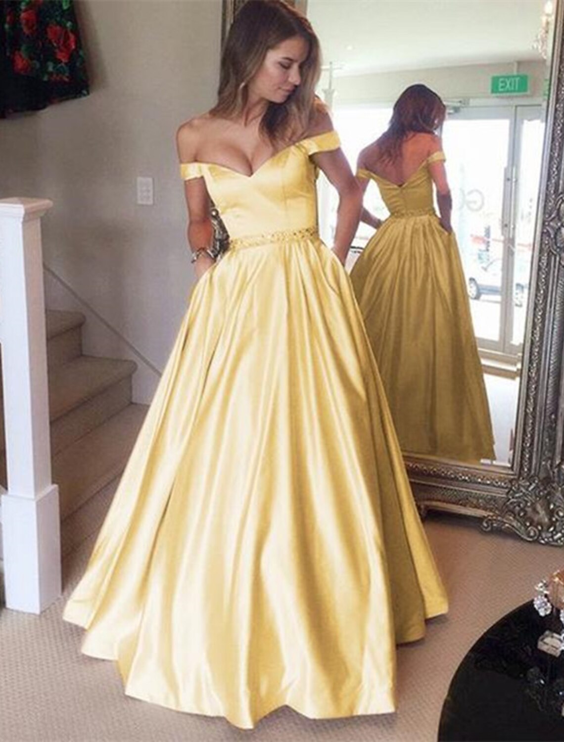 Elegant off-shoulder satin ball gown with pleats and beading.