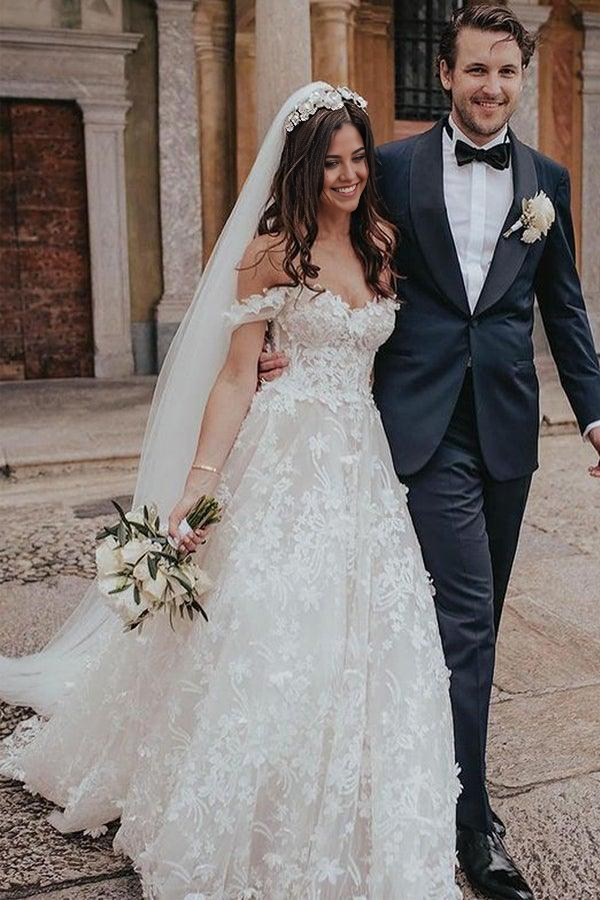 Bride wearing romantic off-shoulder tulle wedding dress.