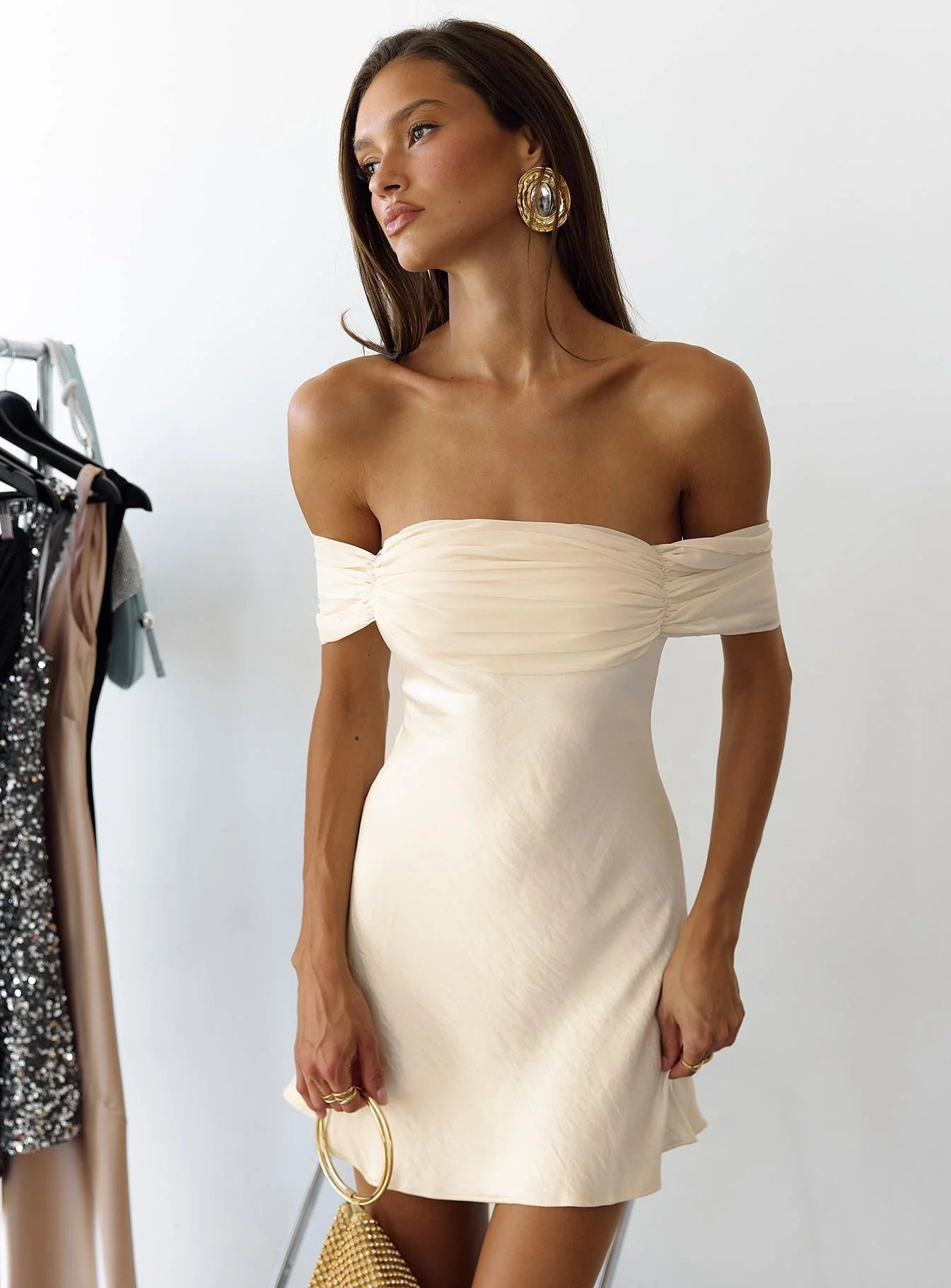 Close-up of the draped ruched bust and off-shoulder neckline of the satin dress.