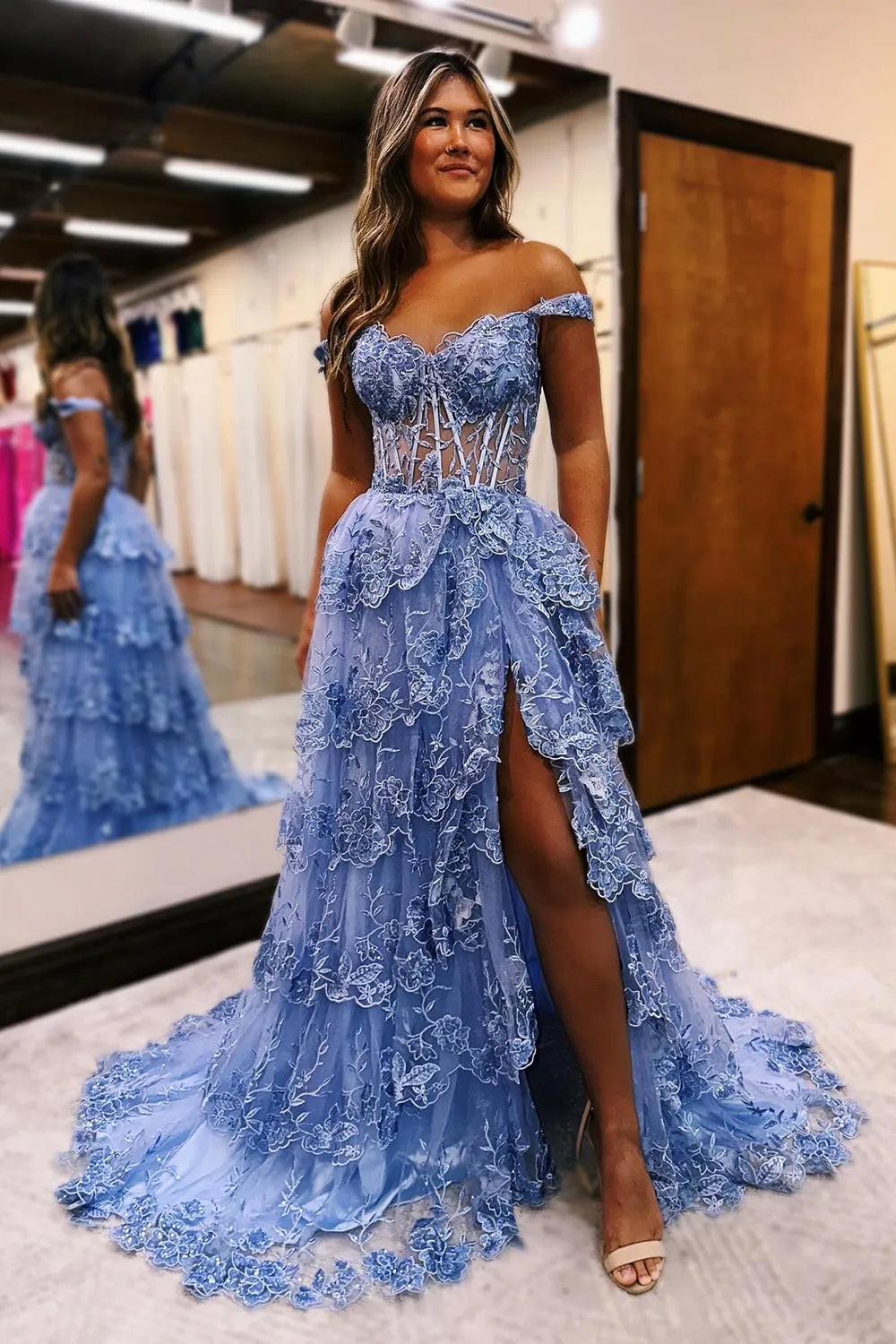 Close-up of appliques on blue tiered prom dress.