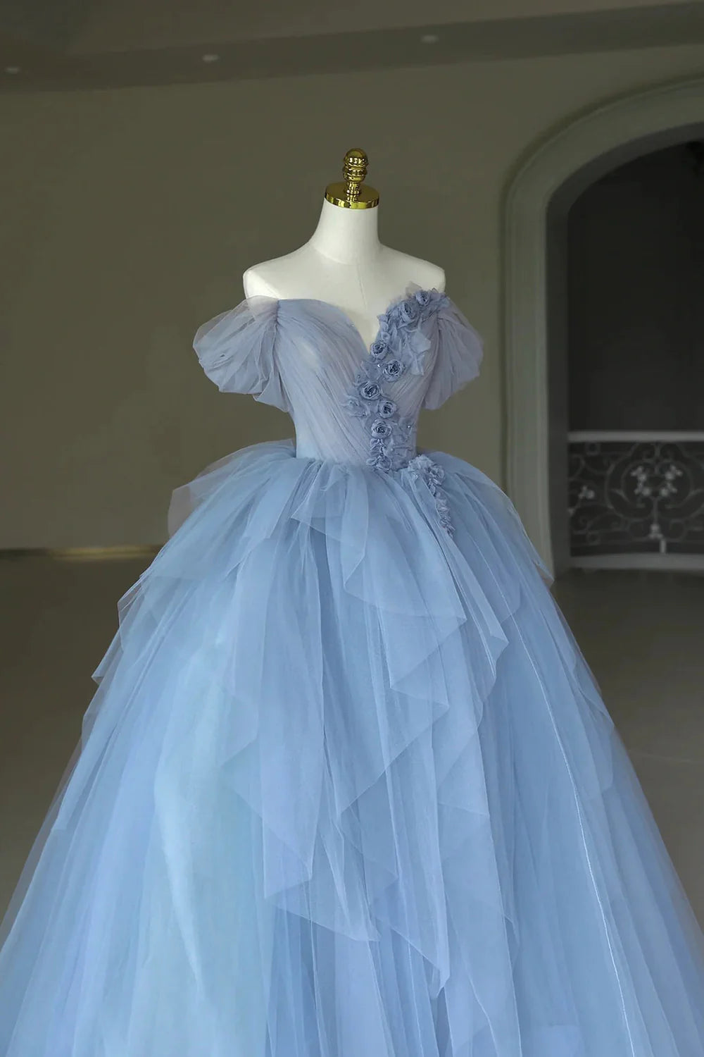 Side view of the elegant off-shoulder tulle gown, showcasing its flowing silhouette.