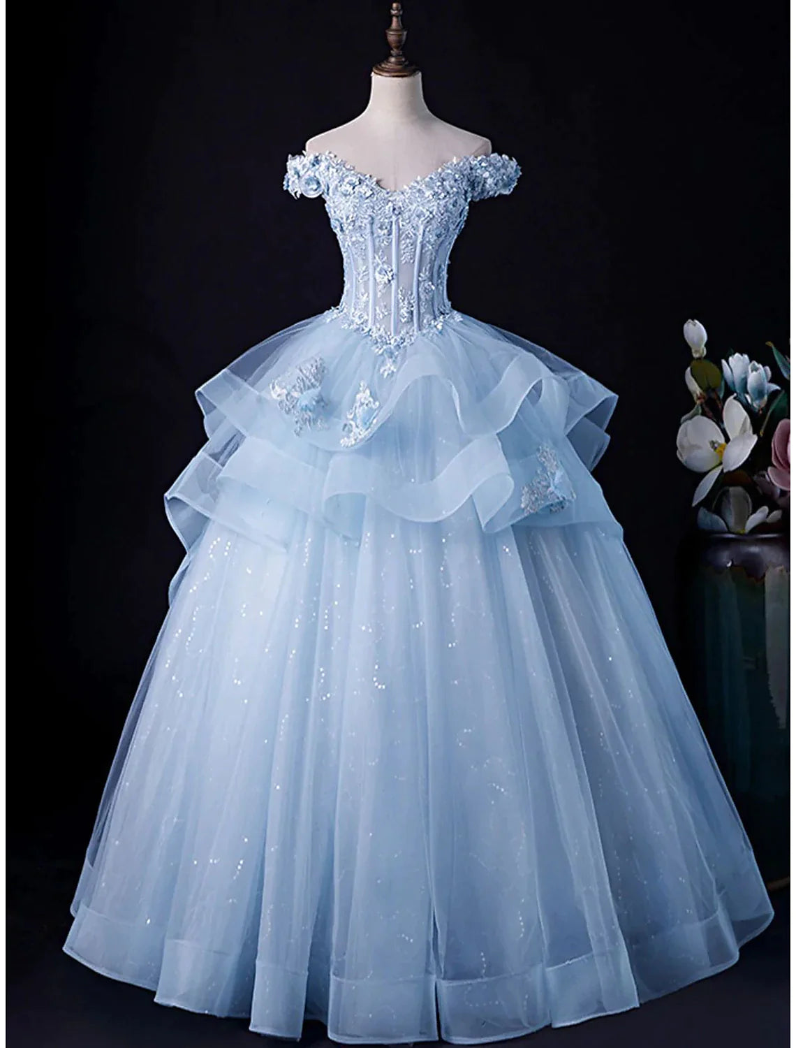 Model wearing an elegant off-shoulder tulle ball gown.