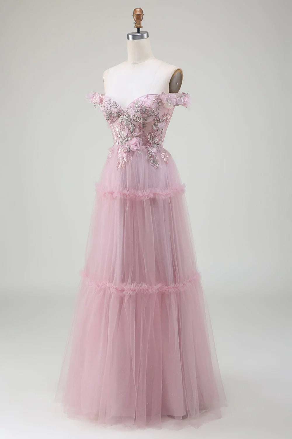 Close-up of the appliques and off-shoulder detail on a blush tulle dress.