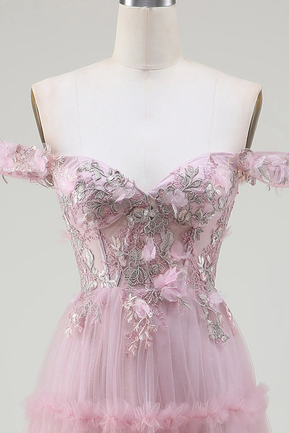 Full length view of a blush off-shoulder tulle prom dress with flowing skirt.