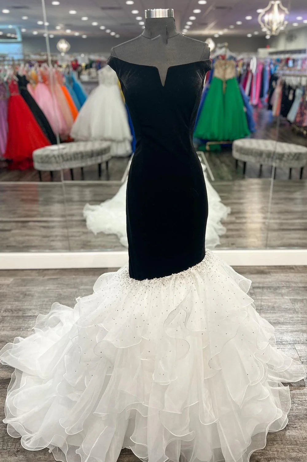 Elegant off-the-shoulder trumpet formal gown in a dark color, suitable for prom or evening events.
