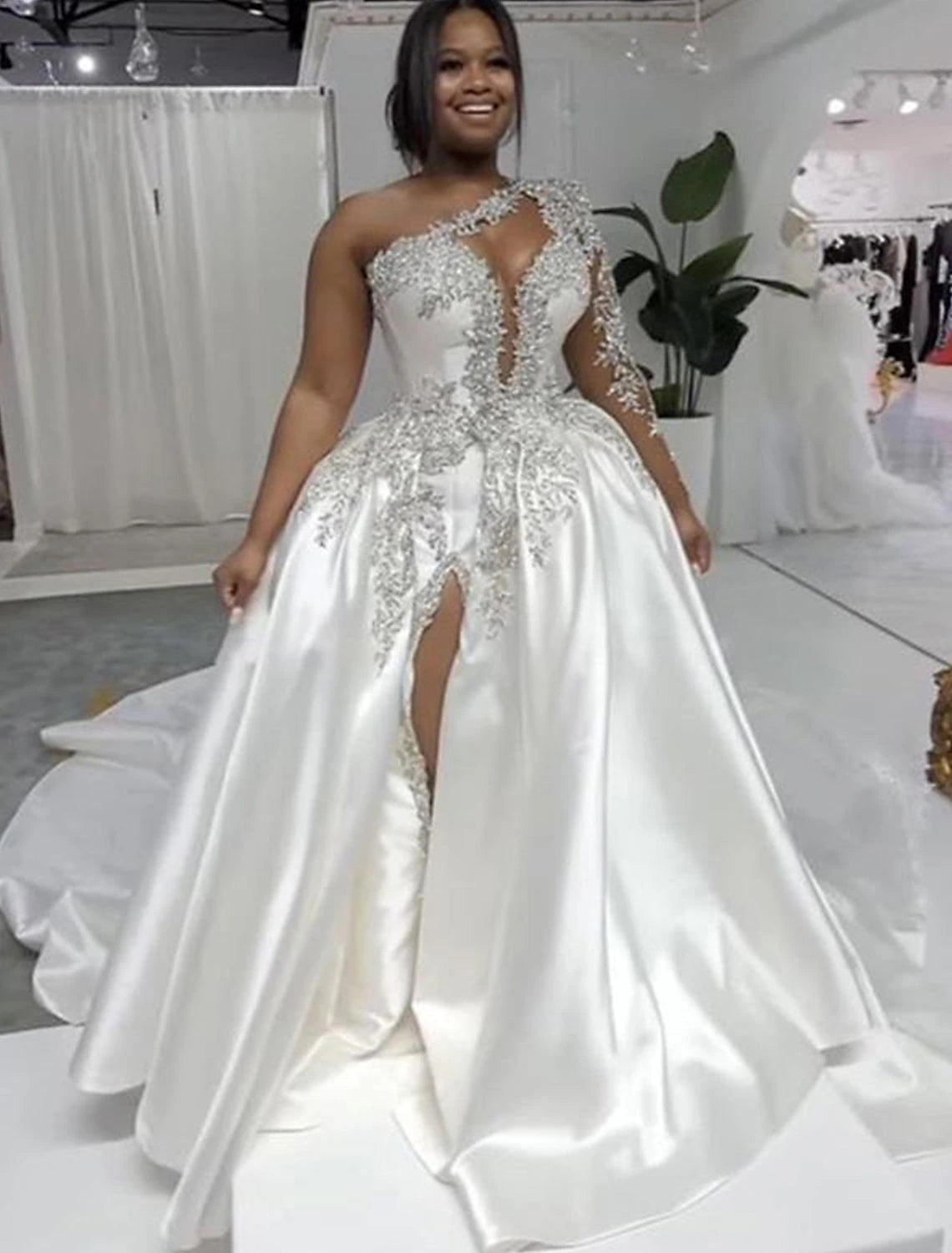 Back view of a formal one-shoulder bridal gown featuring a court train.