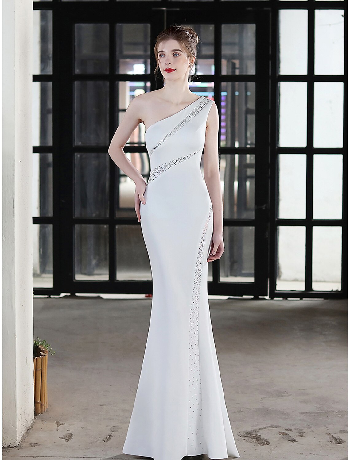 Full view of a glamorous floor-length trumpet dress with a one-shoulder design.