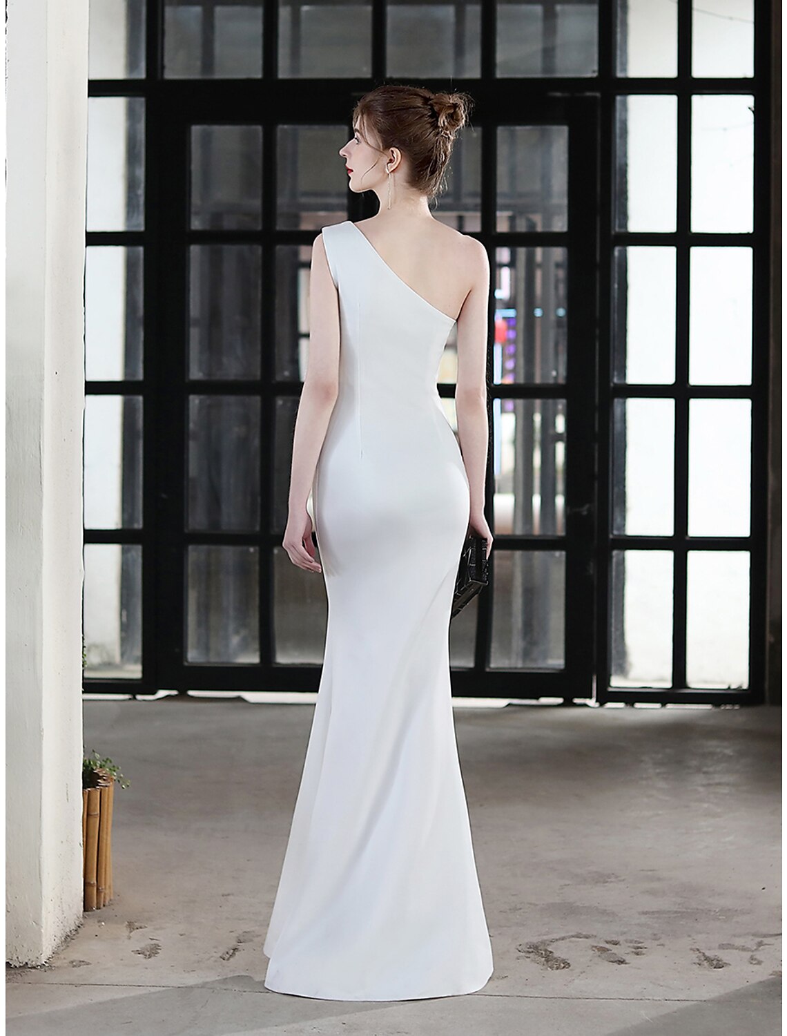 Detail of the one-shoulder neckline and flowing stretch satin skirt.