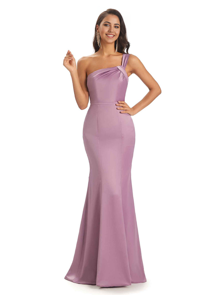 Woman wearing a teal one-shoulder mermaid satin bridesmaid dress.