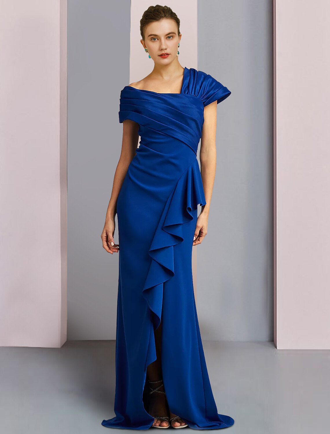 Woman wearing an elegant one-shoulder mermaid trumpet satin gown with ruched ruffles and a sweep train.