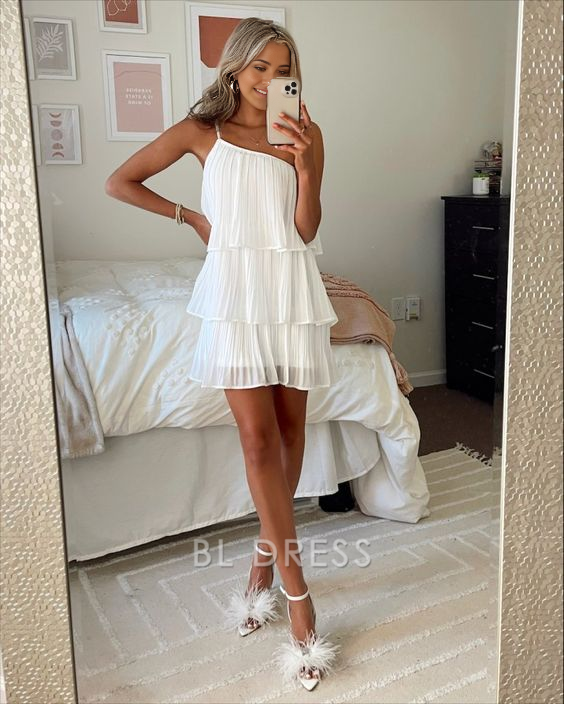 Model wearing a white one-shoulder pleated short A-line homecoming dress.