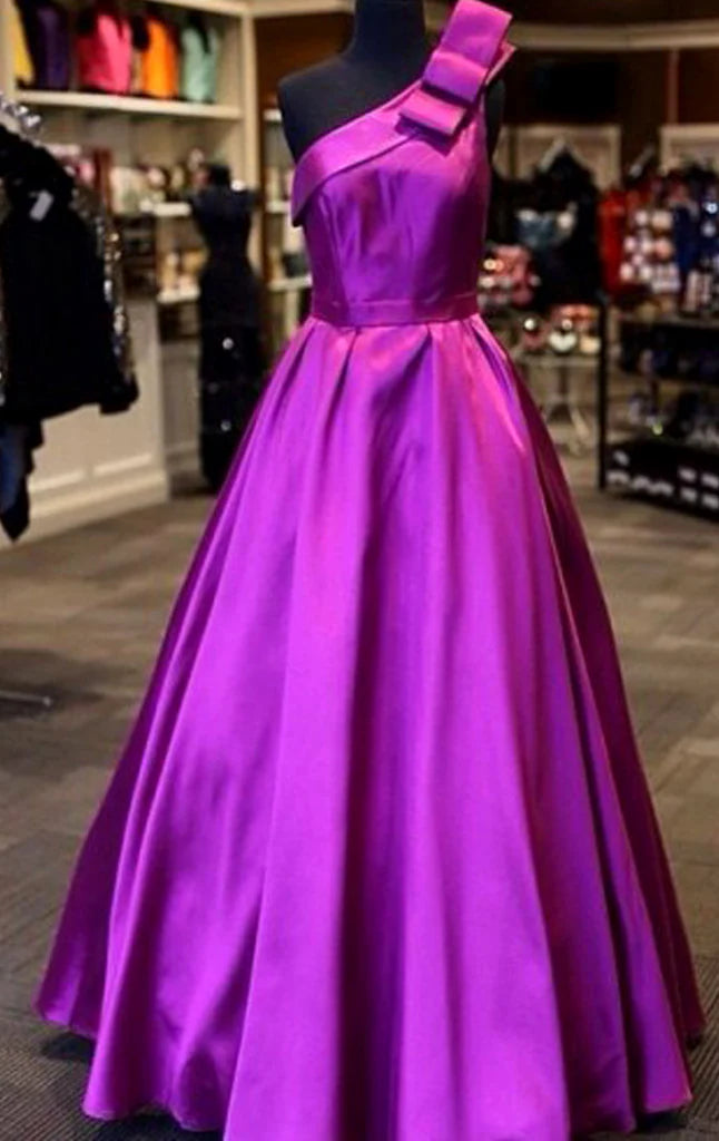 Elegant one-shoulder satin ball gown in a formal setting.