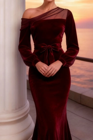 Close-up of the velvet fabric and one-shoulder detail on the burgundy dress.