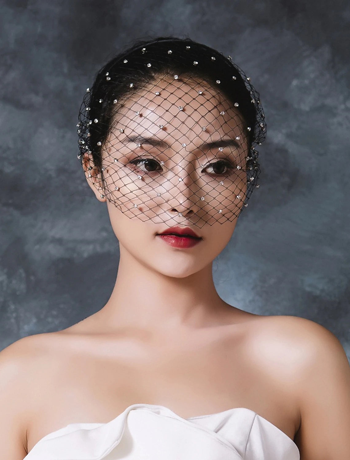Close-up of a European style birdcage veil adorned with rhinestones.