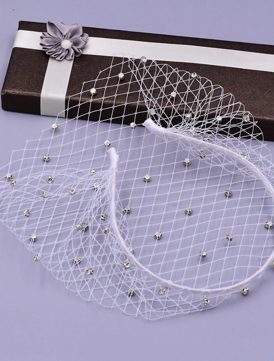 One-tier wedding veil with intricate rhinestone details on tulle.