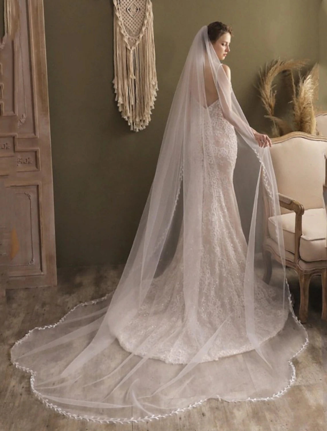 Close-up of intricate lace appliques and faux pearls on a wedding veil.