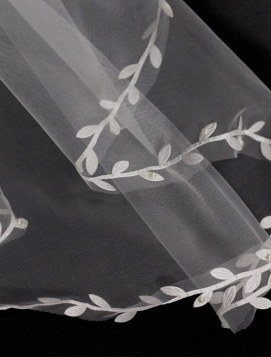 Detail of the soft tulle fabric and embellishments on a bridal veil.