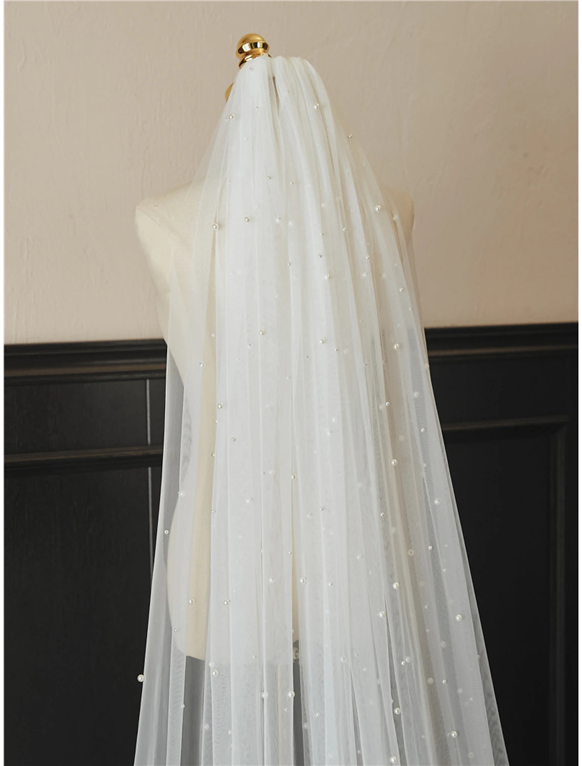Bride wearing a long, one-tier cathedral wedding veil with faux pearls.