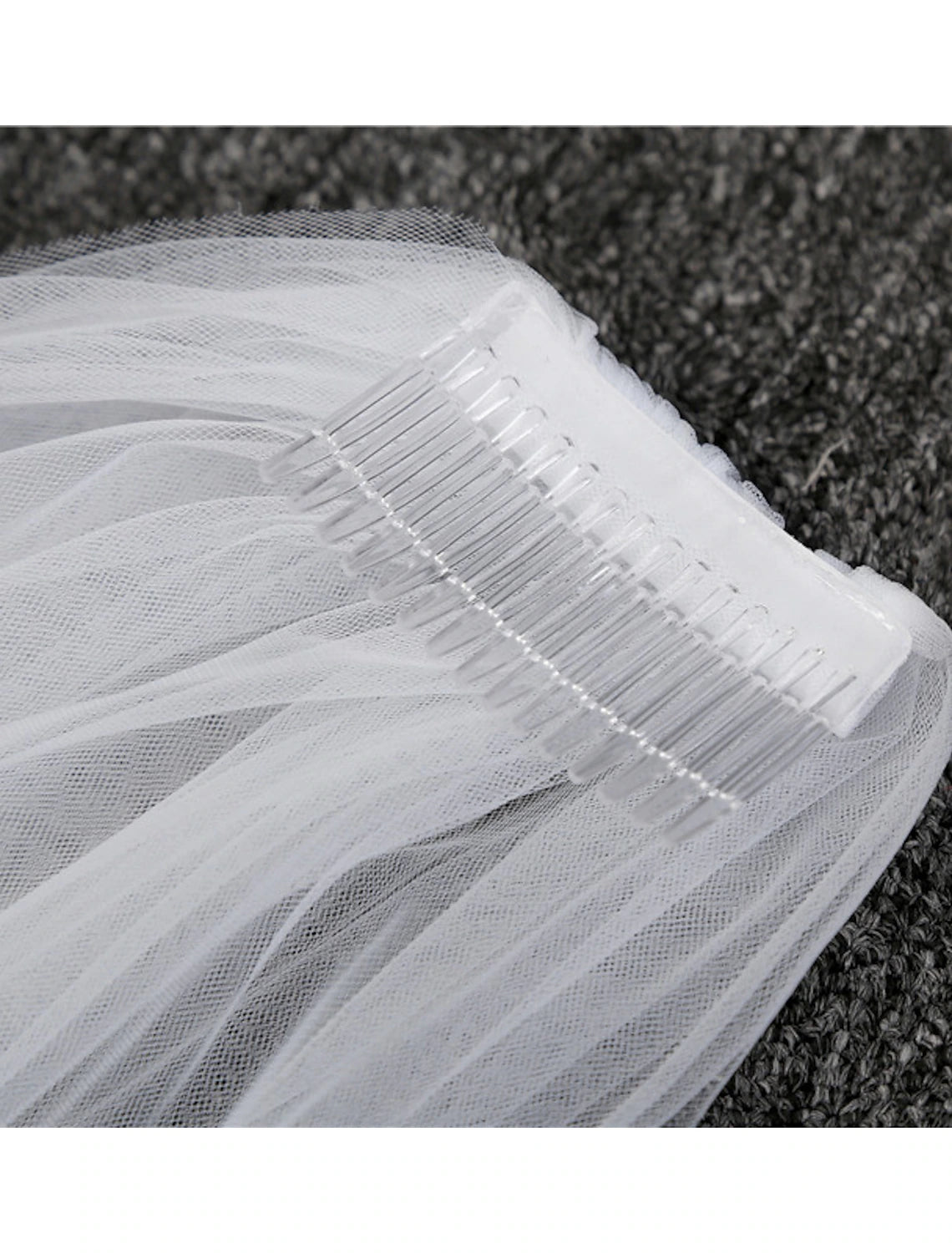 Side view of a bride wearing a simple one-tier chapel length wedding veil, complementing her bridal gown.
