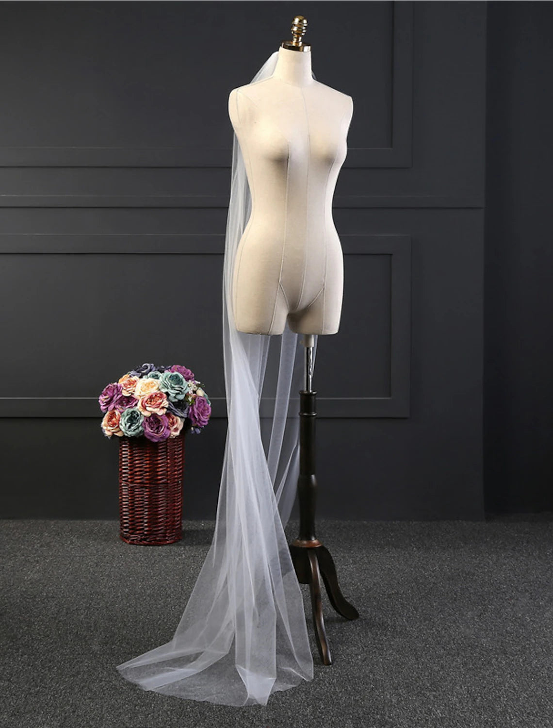 Full length view of a bride walking, her one-tier chapel wedding veil of solid tulle trailing behind her.