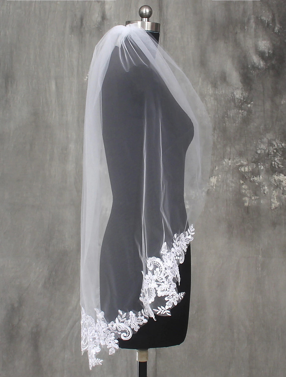 Close-up of the intricate lace appliques on the edge of the wedding veil.