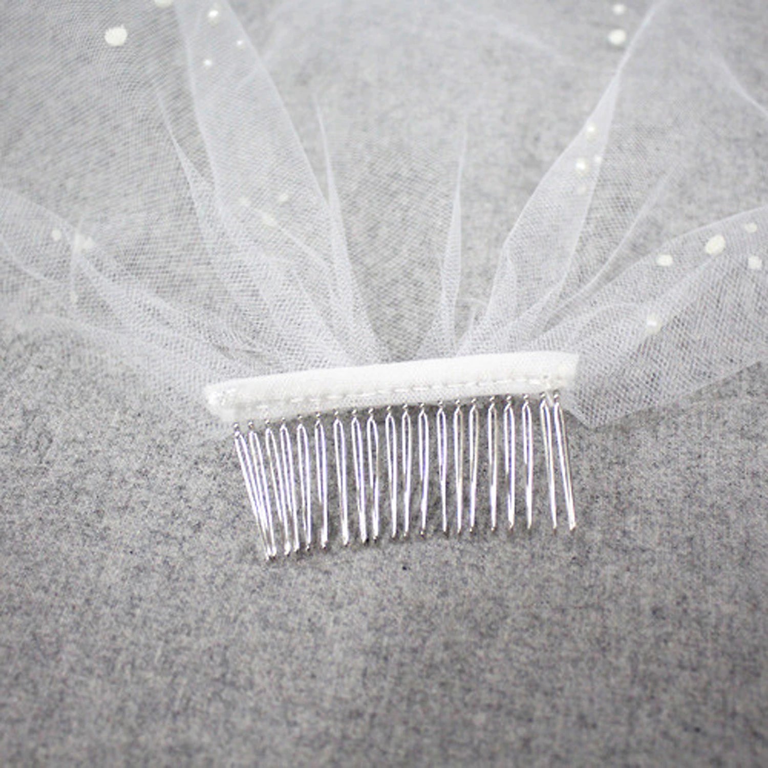 Side view of a one-tier wedding veil with pearl details.