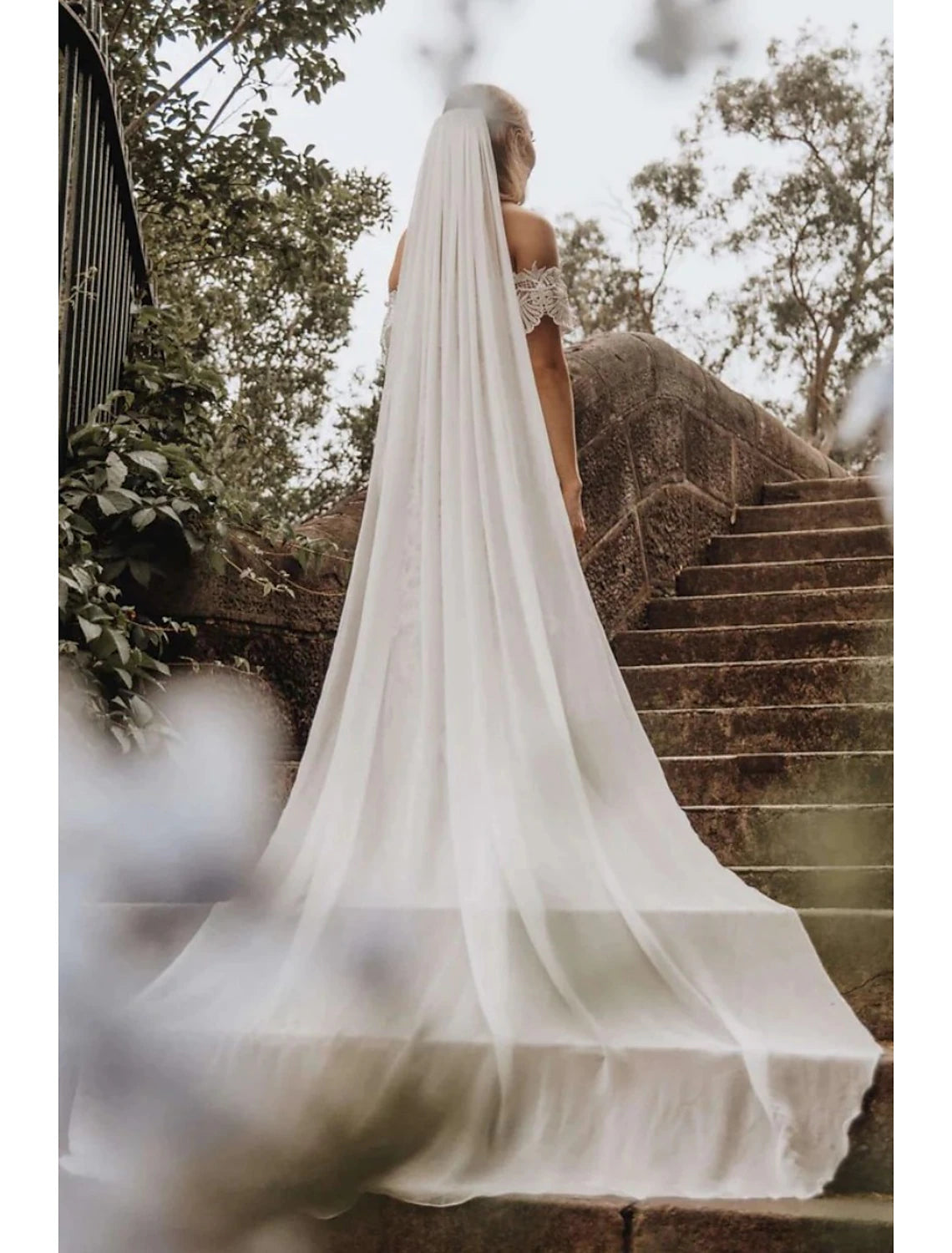 Bride walking, with the cathedral veil gracefully trailing.