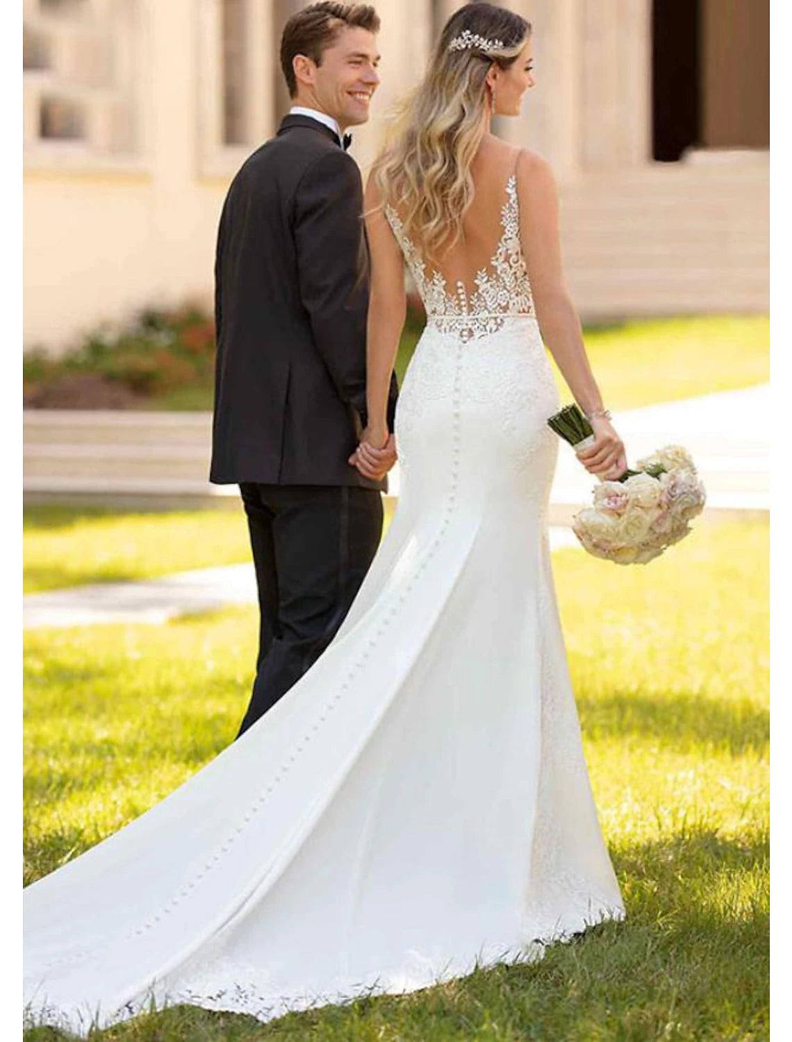 Side profile of the sleeveless mermaid wedding dress with a flowing court train.
