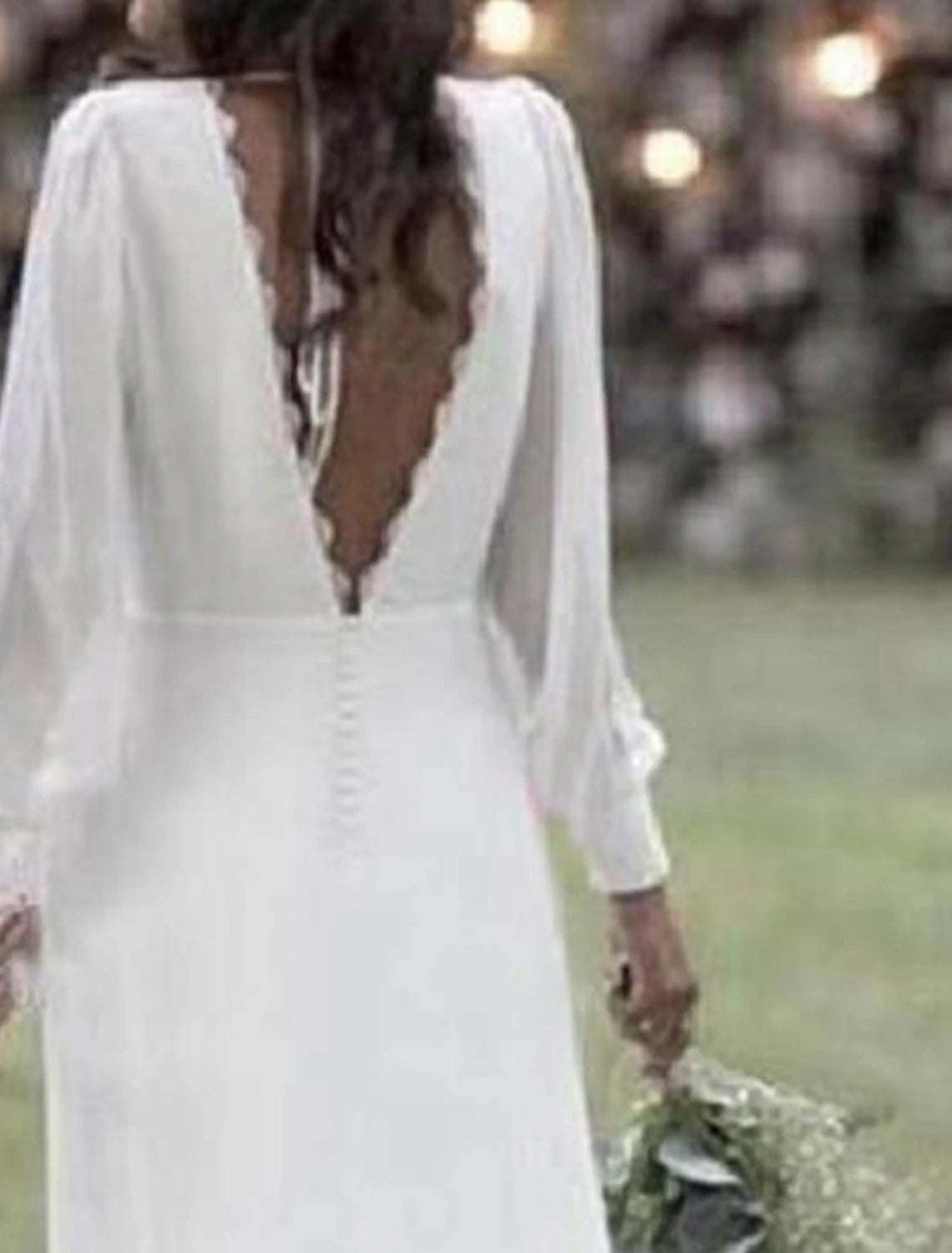 Full length view of the flowing chiffon fabric and sweep train of the bridal gown.