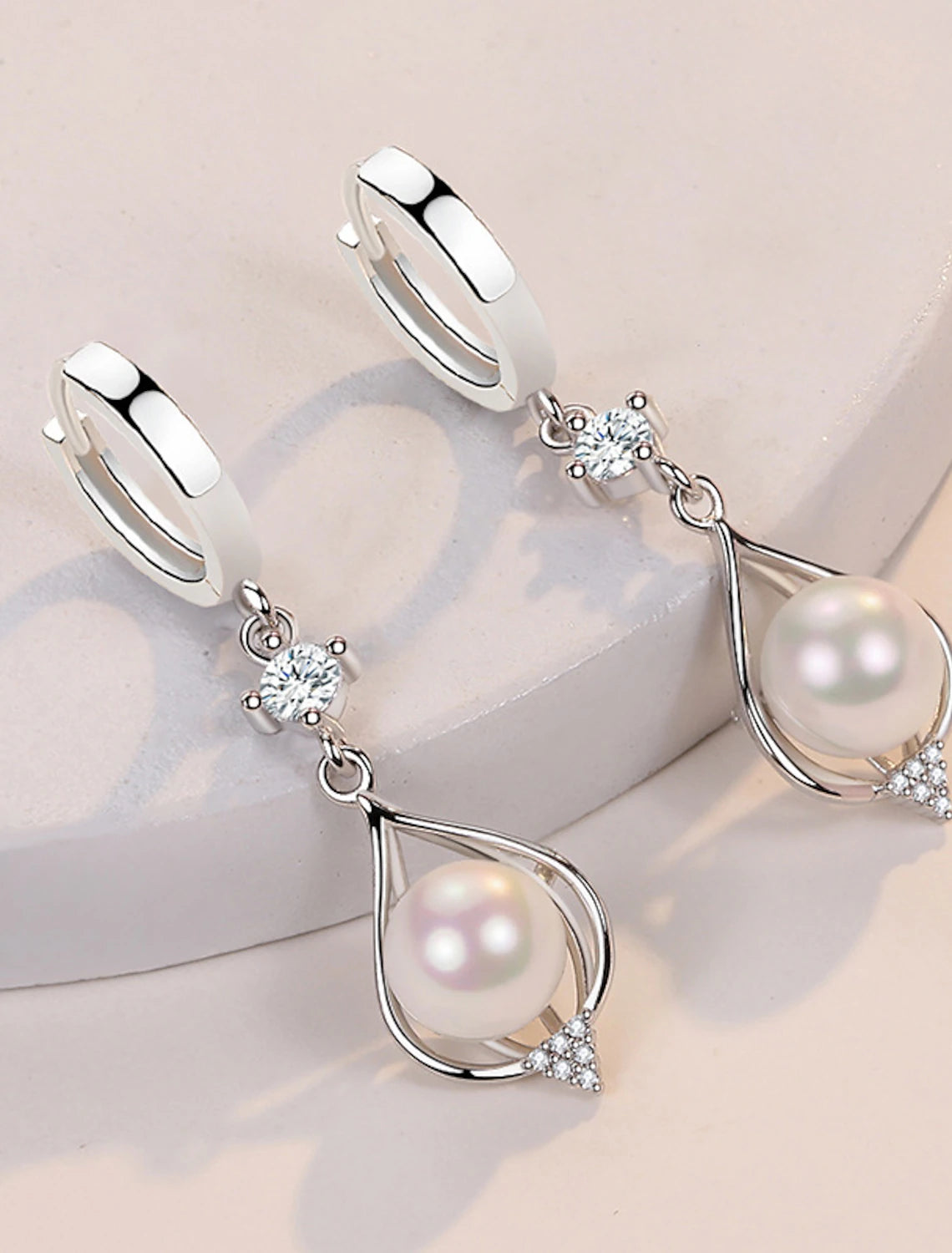 Simple yet elegant pearl drop earrings, front view.