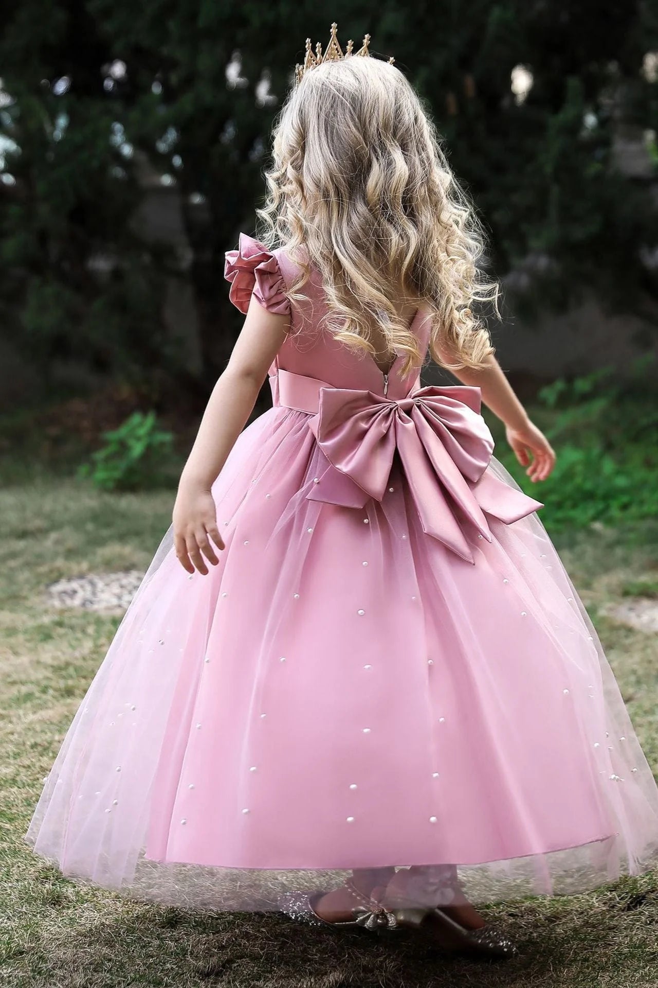 Flower girl in a white A-line dress with a delicate pearl cape.