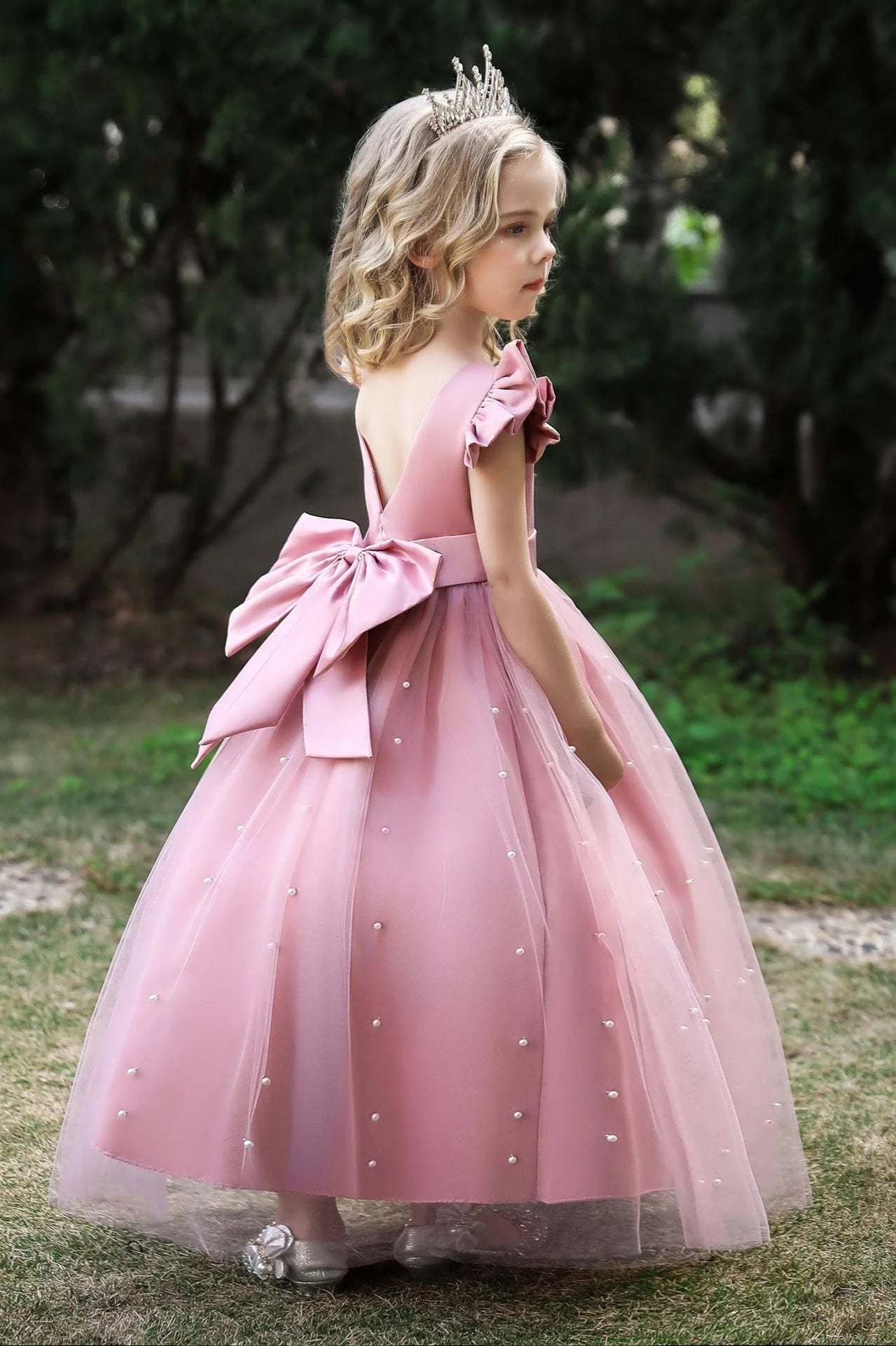 Young girl posing in a beautiful white wedding flower girl dress.