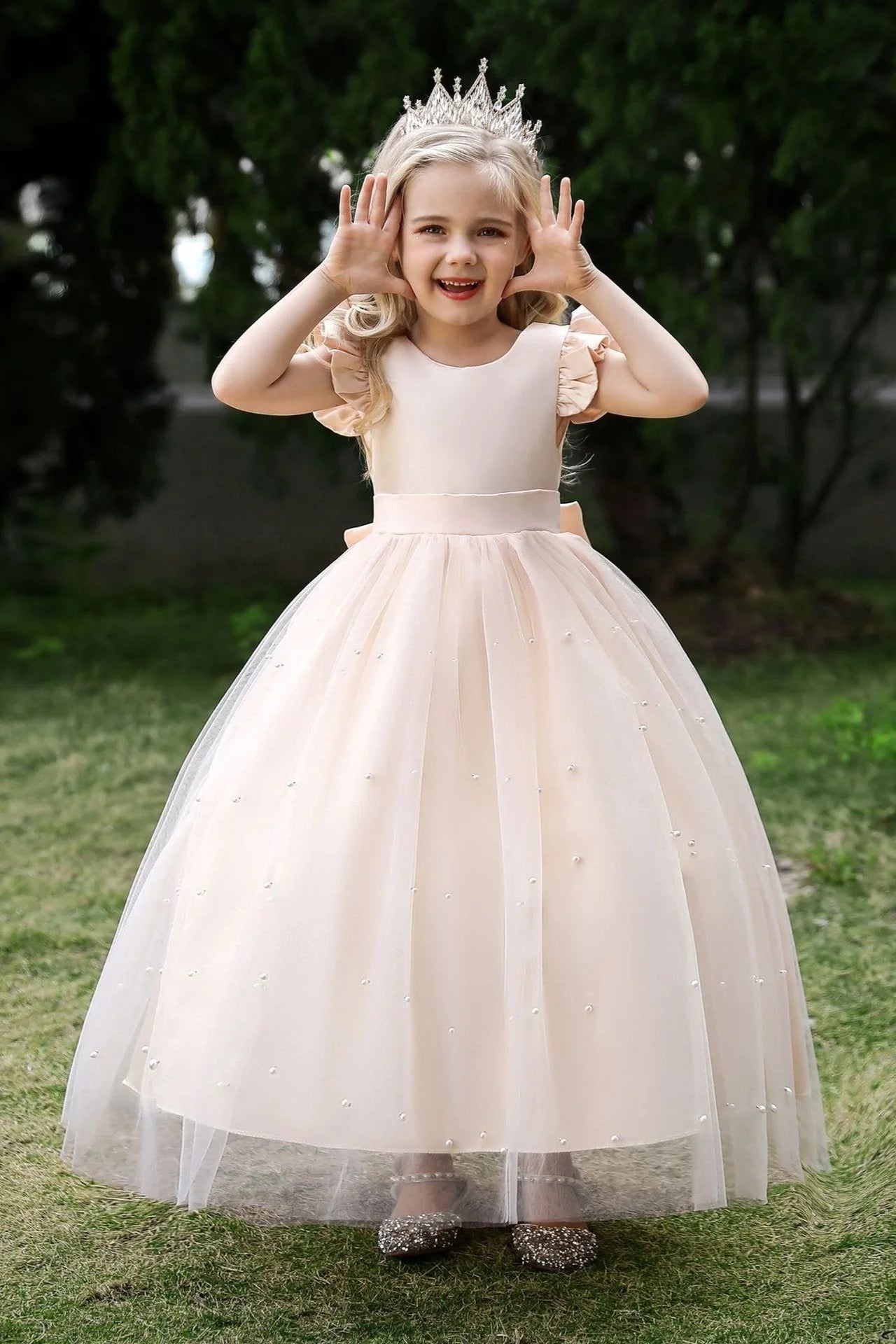 Back view of a white flower girl dress featuring a pearl tulle cape.