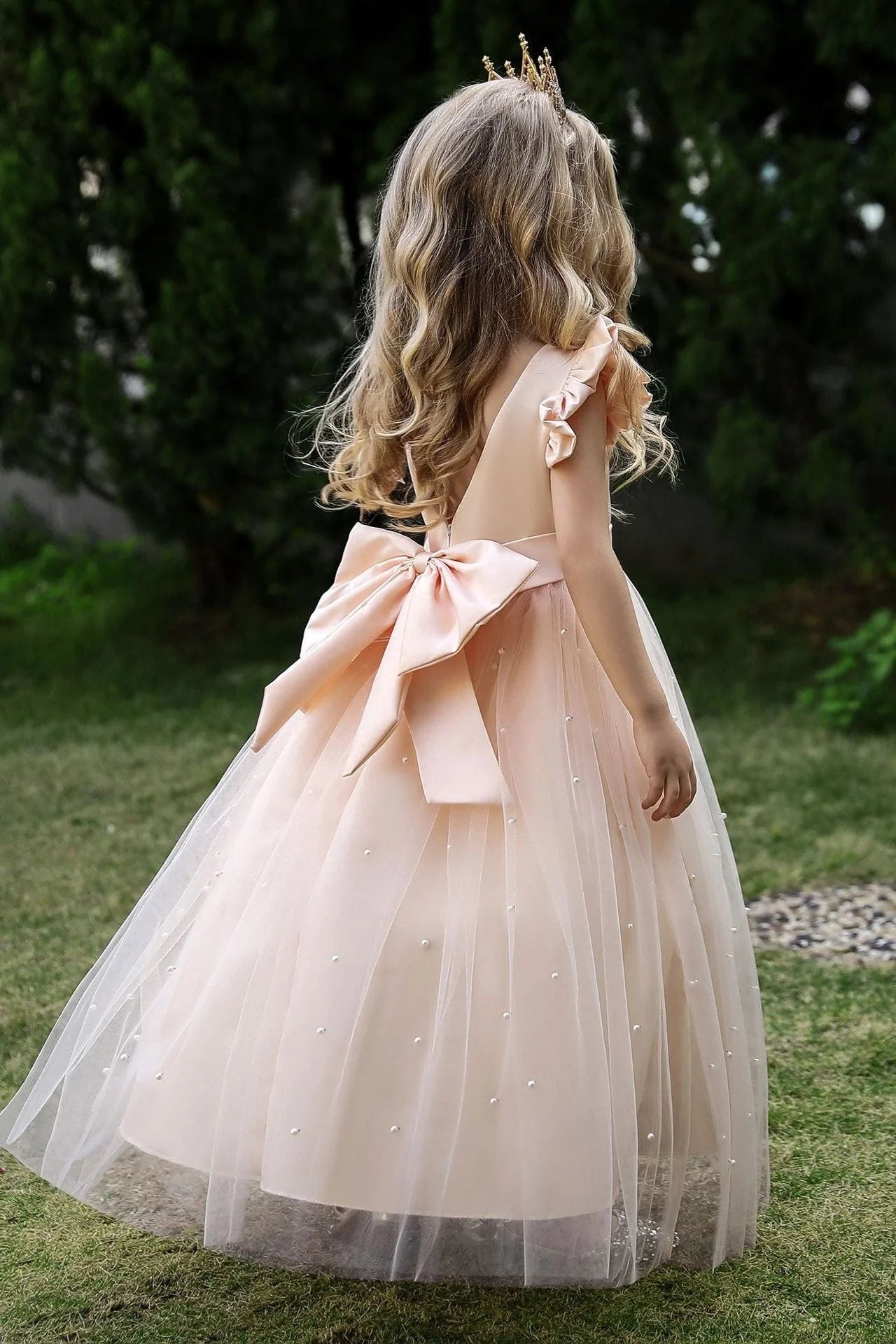 Close-up of the pearl tulle cape on a white flower girl dress.