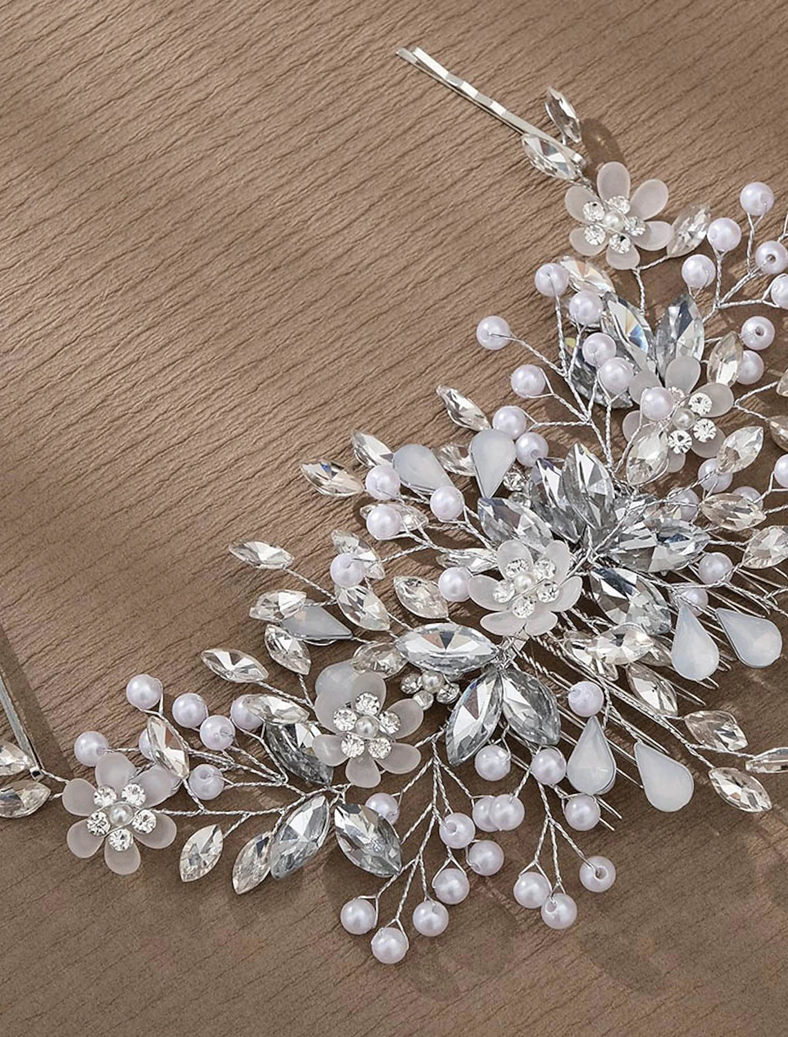 Close-up of a pearl and rhinestone headpiece comb, showcasing intricate details.