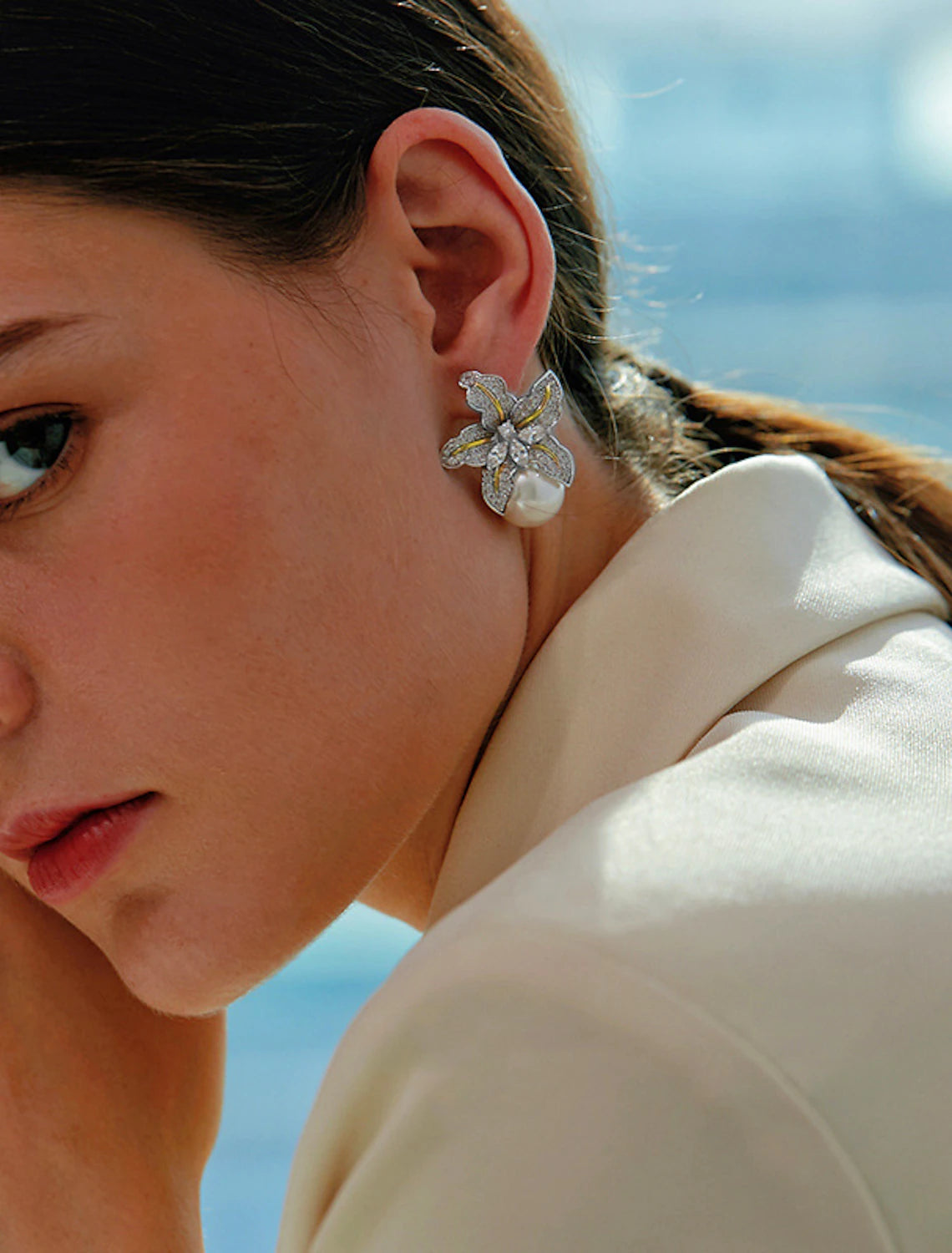 Stylish gold and white petal stud earring worn by a model.