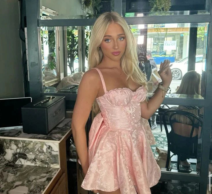 Pink jacquard satin mini dress with corset bodice and large bow back.