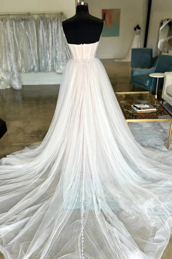 Full view of a romantic A-line pleated tulle bridal gown with a sweetheart neck.