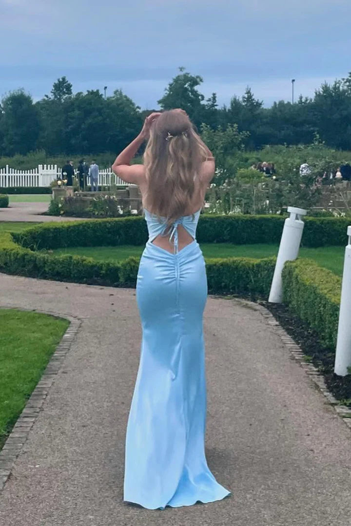 Back view of a blue ruched mermaid long prom dress with a train.