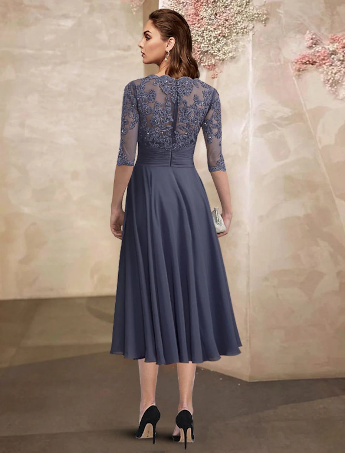 Back view of the A-line tea length dress with ruched details and beading.