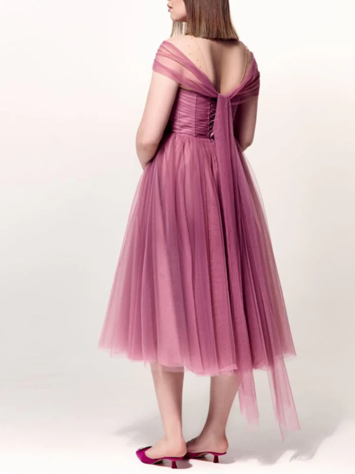 Model in a plus size off-the-shoulder A-line cocktail dress, side view.