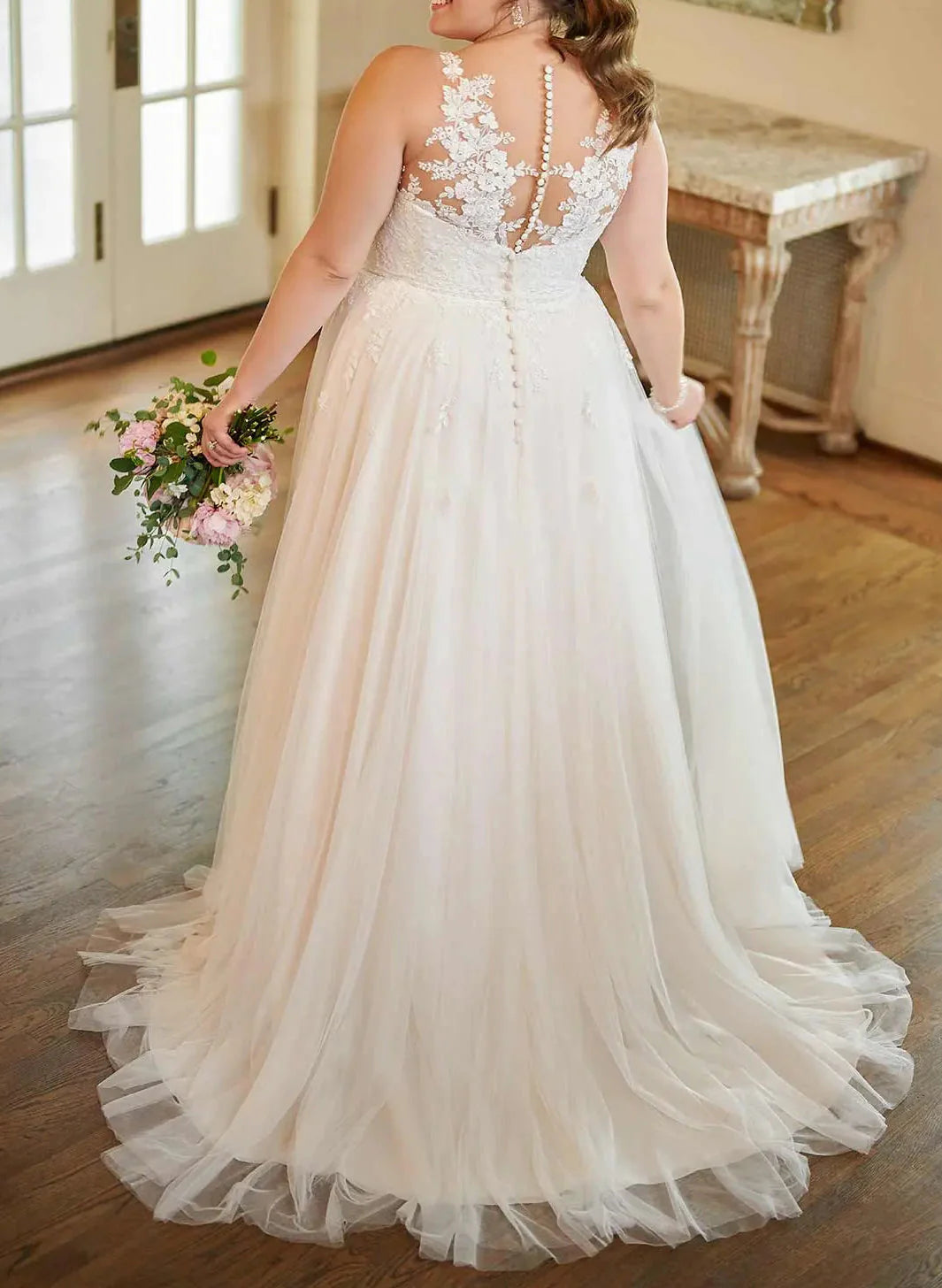 Close-up of the intricate applique lace detail on the V-neckline of the wedding dress.