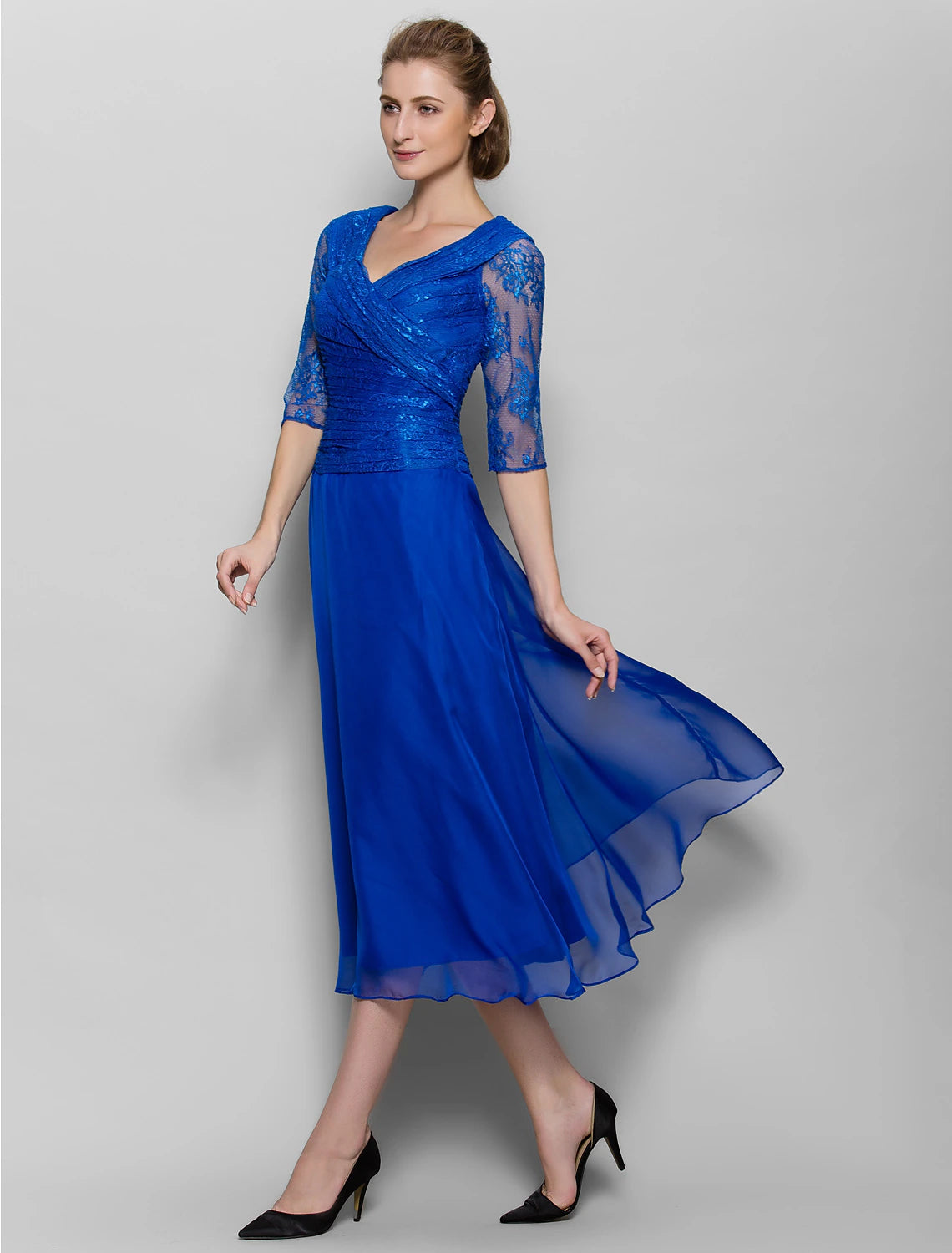 Model showcasing the half sleeves and ruched waist of the plum dress.