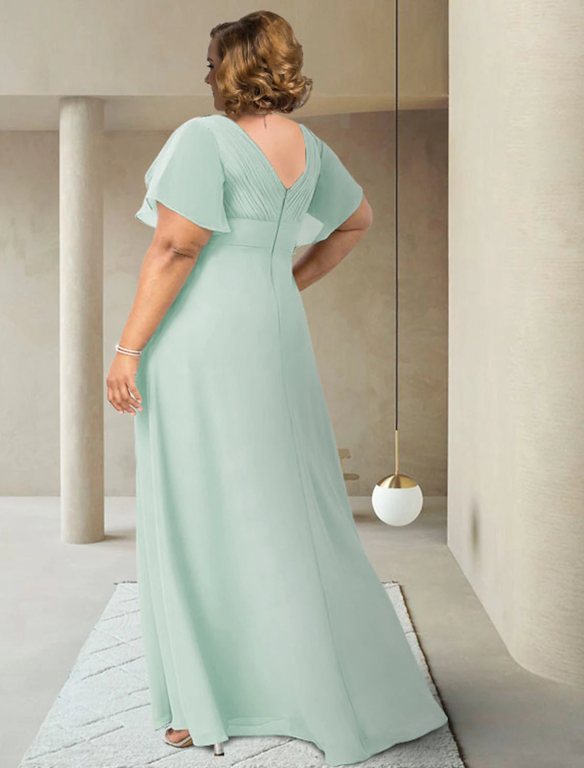 Elegant chiffon gown with ruching and sash detail on a model.